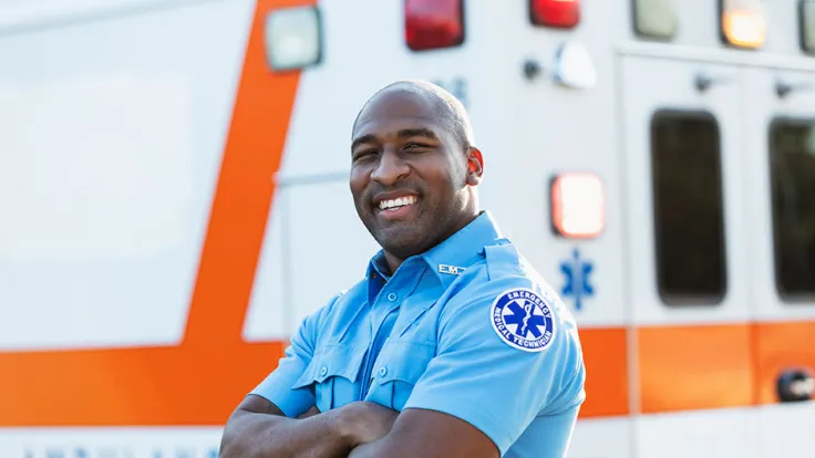 Professional EMT standing next to an ambulance