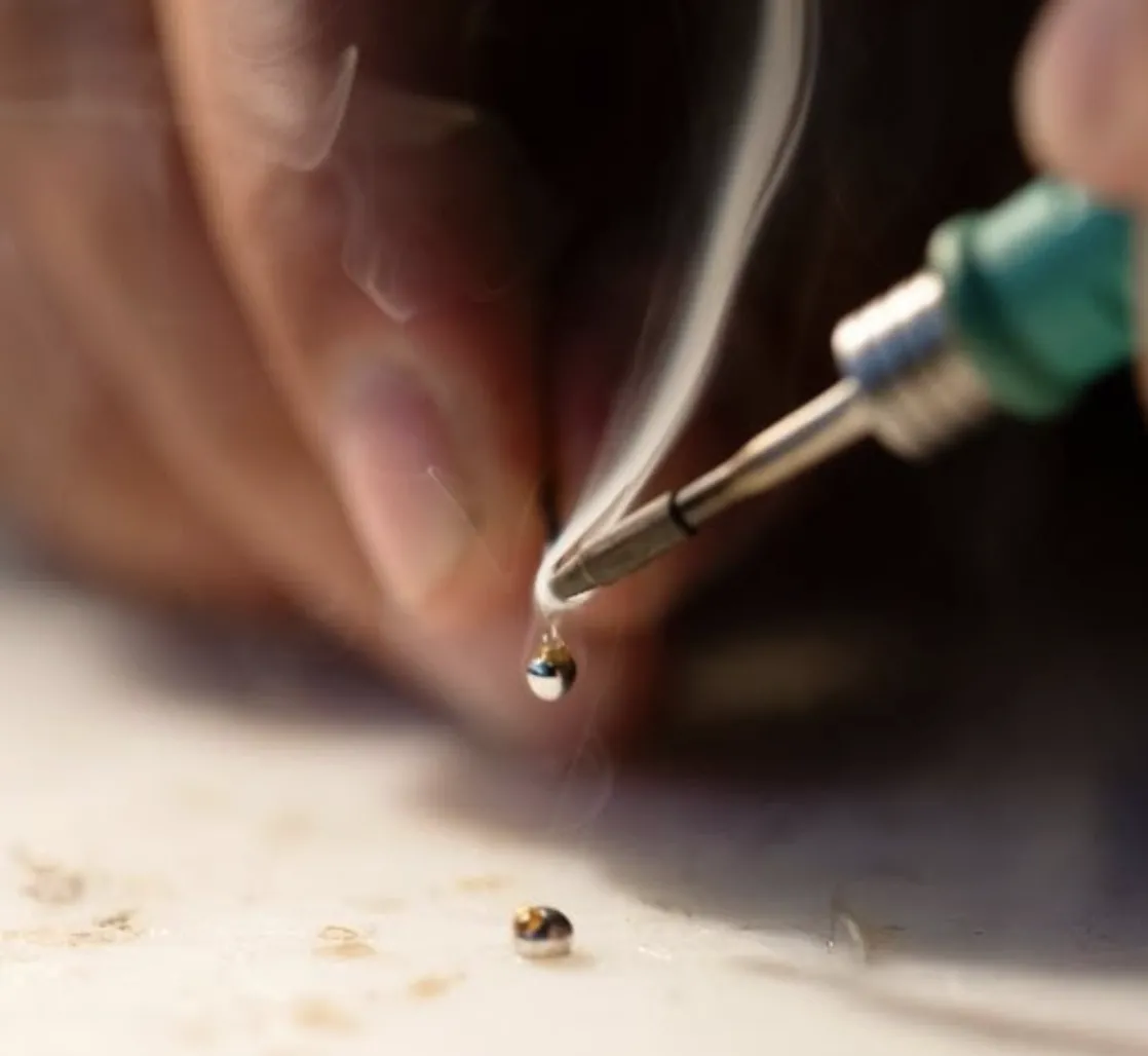 Closeup of a drop of silver solder dripping from a hot soldering iron