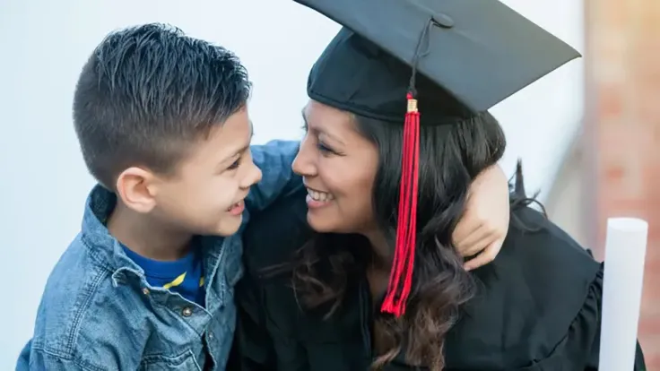 Mother graduate in cap and gown with son