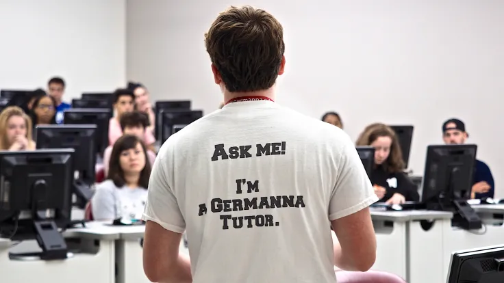 Germanna Tutor facing students with a t-shirt saying to "Ask Me!"