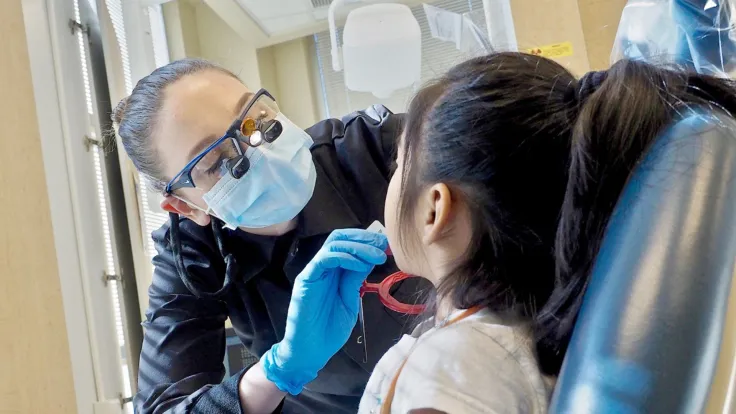 Dental hygienist examining patient at the Moss Clinic