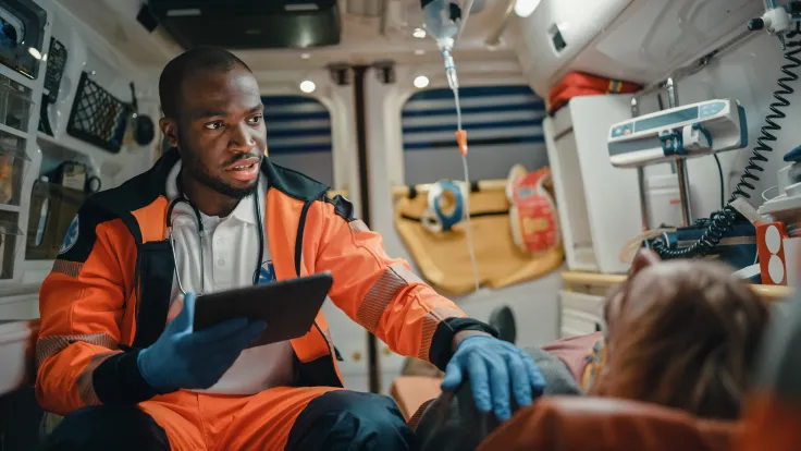 Advanced Emergency Medical Technician working with a subject inside of an ambulence