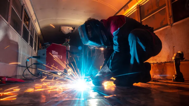 person welding inside a bus