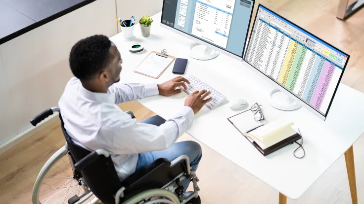 A billing and coding specialist entering data on a computer